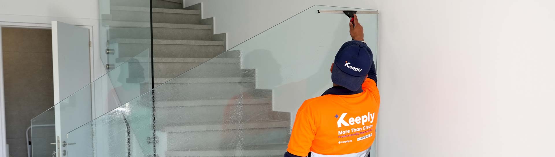 a keeply professional employee providing residential glass cleaning service for modern interior.