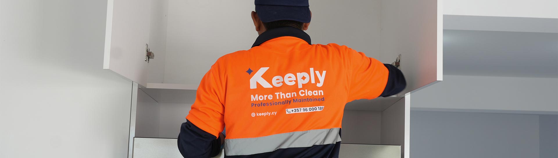 A Keeply employee in uniform cleaning a modern home closet interior.
