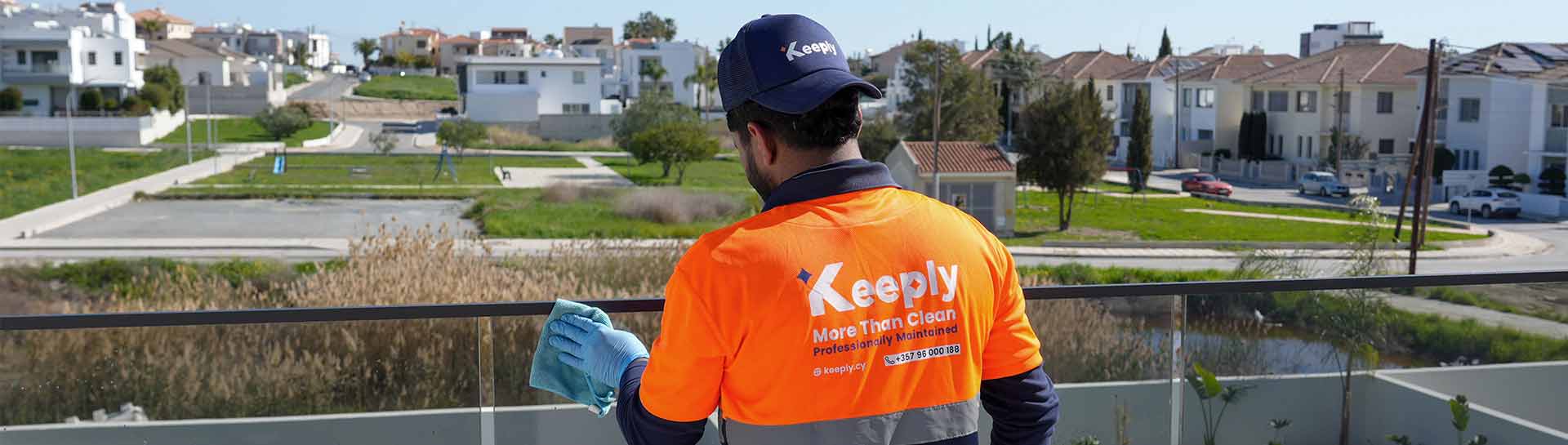 A keeply employee in keeply custom cleaning a balcony glass railing.
