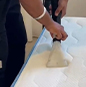 close up of a keeply employee using a vacuum machine to clean a mattress.