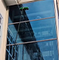 close up of a building outer windows being cleaned with ro machine brush by a keeply employee
