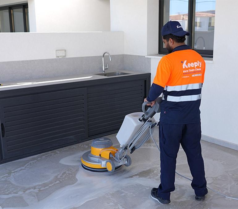 Keeply employee performing professional floor polishing and cleaning using a floor scrubbing machine.