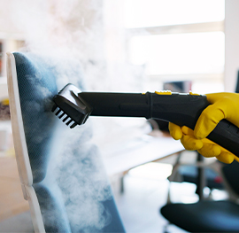 A keeply cleaner using a handheld steam brush to deep steam clean and sanitize furniture