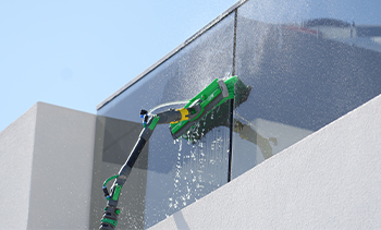 a close up of a ro water machine brush used to clean outdoor glass of a house.