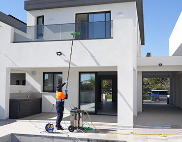 keeply employee using the RO water machine in order to clean the Glass of a house